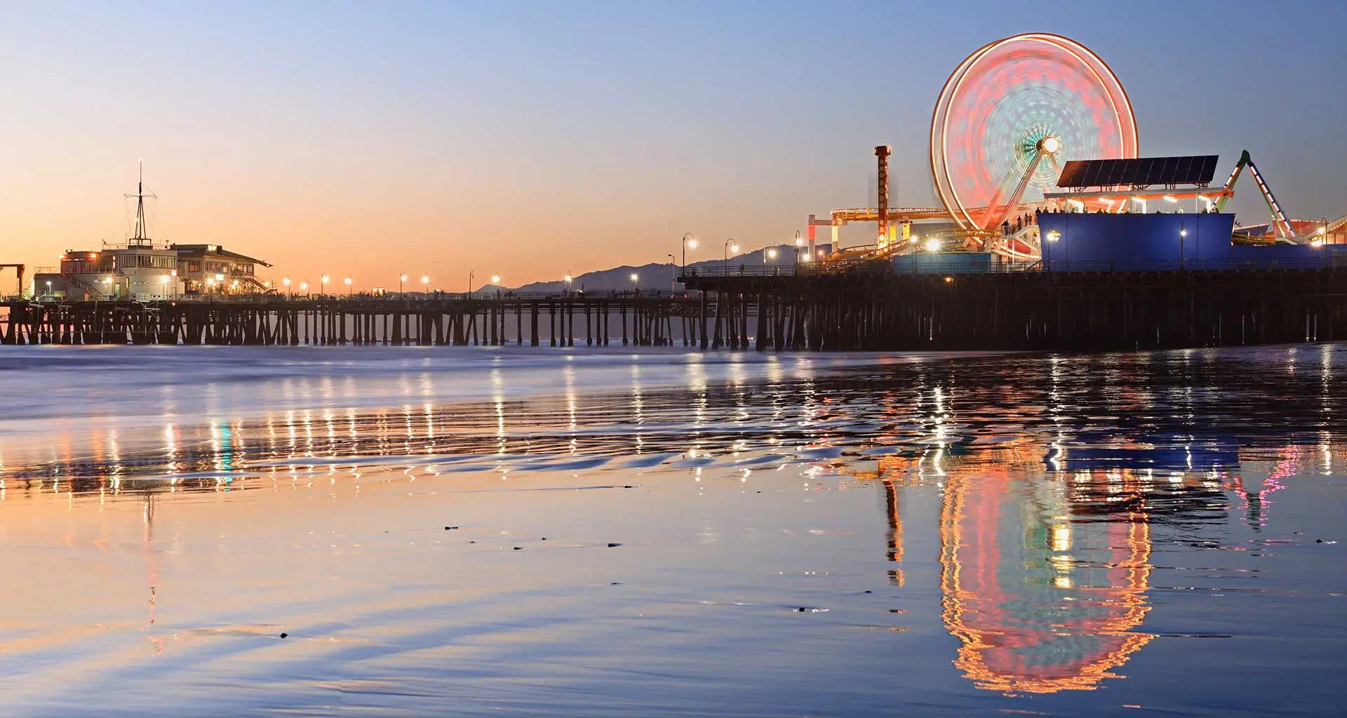 The Santa Monica Pier at Night showing the ocean and ferris wheel lit up in the background