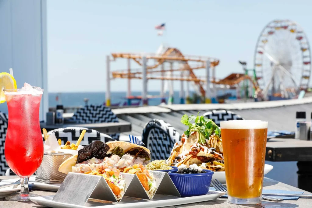 Seaside on the Pier Rooftop featuring blackened mahi tacos, fries, loaded nachos, beer, and a strawberry margarita